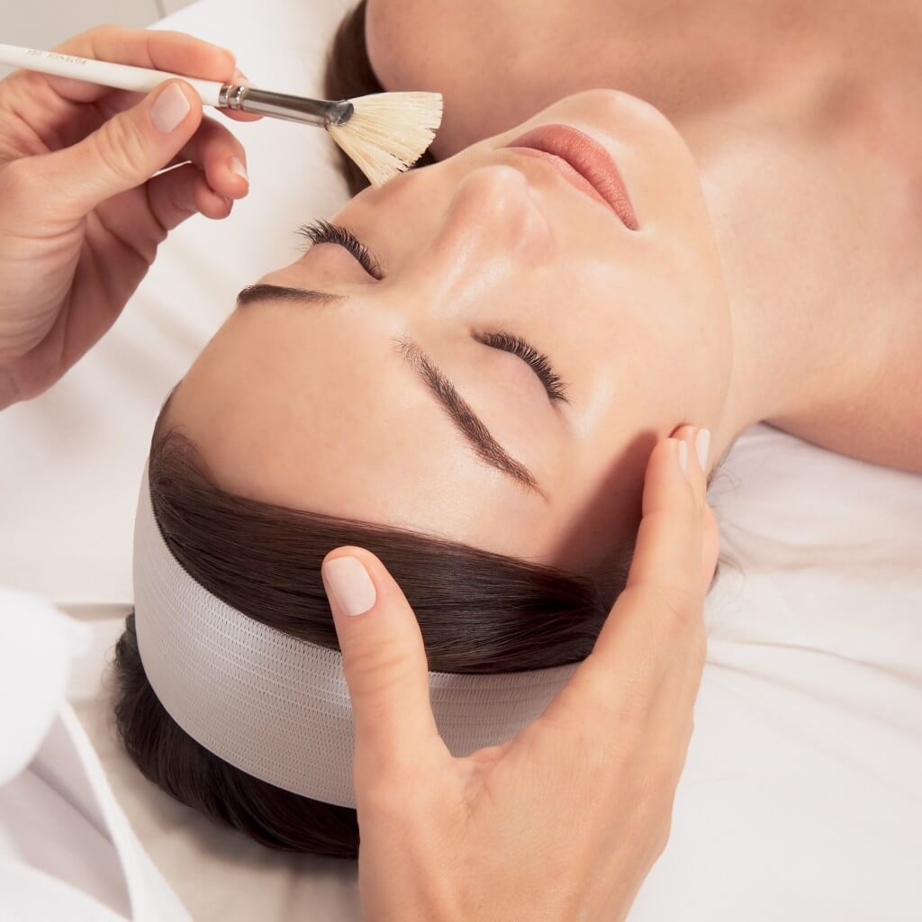 Woman with vitamin C mask showing brighter, more even skin tone after chemical peel series - SkinScience