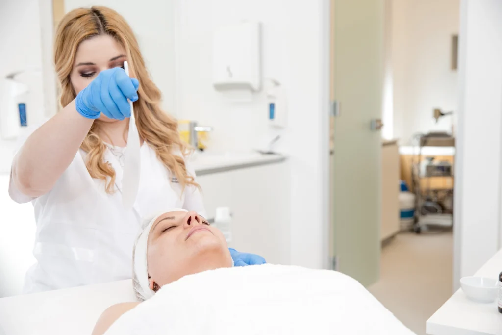 Clinician applying a medical-grade chemical peel solution to a client's face - SkinScience