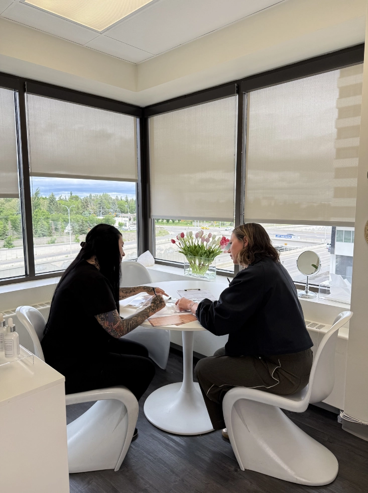 Patient and SkinScience clinician reviewing a customized tattoo removal treatment plan during a consultation in Calgary - SkinScience Patient and SkinScience clinician reviewing a customized tattoo removal treatment plan during a consultation in Calgary - SkinScience